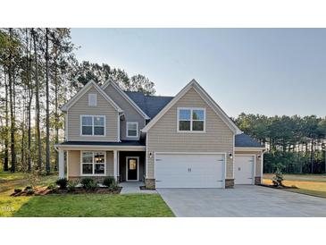 Charming two-story home with a three car garage and well-manicured lawn at 11 Little Gem Ln, Fuquay Varina, NC 27526