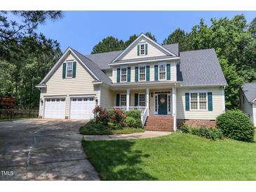 Charming two-story home with well-manicured lawn, colorful flowerbeds, and a three car attached garage at 119 Marykirk Pl, Garner, NC 27529
