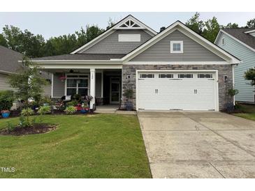 Charming single-story home featuring a well-manicured lawn and a welcoming covered front porch at 120 Bramble Ln, Clayton, NC 27527