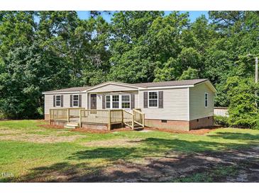 Charming home featuring a spacious wooden deck, neutral siding and neatly landscaped surroundings at 1392 L Cooper Rd, Cameron, NC 28326