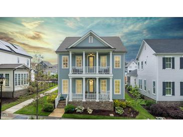 Charming two-story home featuring double balconies, a beautifully landscaped yard, and classic architectural details at 1423 Tannin Dr, Durham, NC 27713
