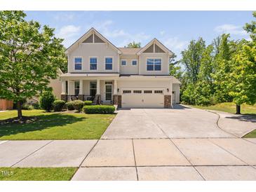 Charming two-story home featuring a manicured lawn, attached two-car garage, and inviting front porch at 1458 Wragby Ln, Apex, NC 27502