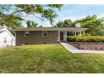 Ranch-style home featuring a covered front porch and mature landscaping on a sunny day at 2125 Cheek Rd, Durham, NC 27704