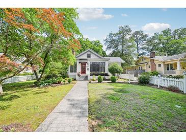 Charming home featuring a landscaped front yard, a walkway, and a vibrant red front door at 2209 The Circle, Raleigh, NC 27608