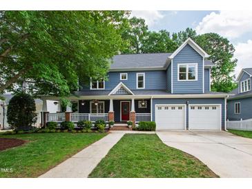 Charming two-story home with a well-manicured lawn, large front porch, and a two-car garage at 2309 Filigree Ct, Raleigh, NC 27614