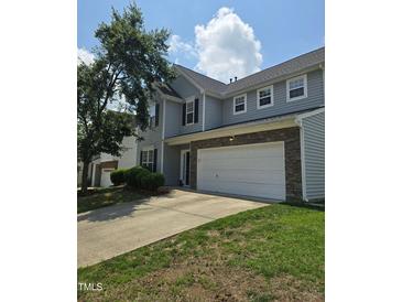 Inviting two-story home featuring a spacious driveway and a beautifully maintained lawn at 2330 Lazy River Dr, Raleigh, NC 27610