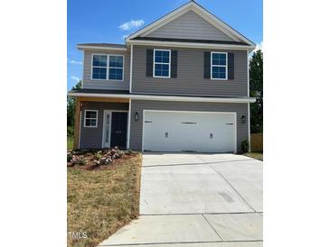 Charming two-story home with gray siding, a two-car garage, and a well-manicured lawn at 261 Plains Dr # 263, Burlington, NC 27217