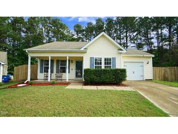 Charming single-story home with a well-manicured lawn, cozy front porch with rocking chairs, and attached one car garage at 3709 Fan Palm Ct, Raleigh, NC 27616