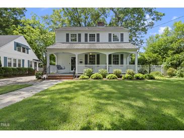 Charming two-story home featuring a welcoming front porch, lush lawn, and mature trees offering curb appeal at 406 E Lee St, Smithfield, NC 27577