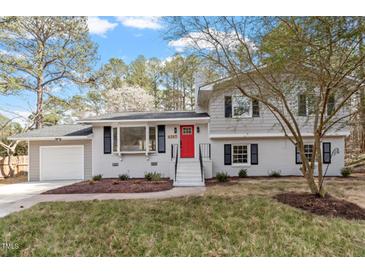 Charming two-story home features a red front door, classic shutters, and a well-manicured lawn, blending traditional style with modern updates at 4307 Pope Rd, Durham, NC 27707