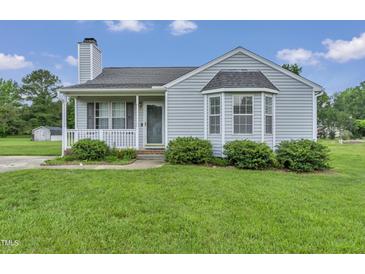 Charming home with a well-maintained lawn, inviting porch, and a classic bay window at 5849 Rocking Chair Dr, Youngsville, NC 27596