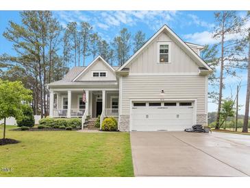 Charming home featuring a covered front porch, two-car garage, and manicured lawn at 813 Whitley Way, Wendell, NC 27591