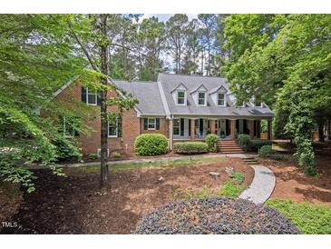 Charming brick home featuring a welcoming front porch and meticulously maintained landscaping at 9900 Two Robins Ct, Raleigh, NC 27613