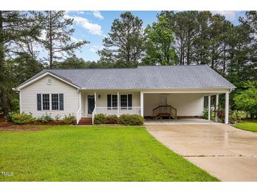 Charming single-story home featuring a well-manicured lawn and a convenient covered carport at 1000 Strobus Ct, Wendell, NC 27591