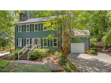 Charming two-story home features a brick walkway, mature landscaping, and a convenient attached garage at 207 Old Forest Creek Dr, Chapel Hill, NC 27514