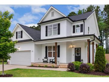 Charming two-story white home featuring black shutters, a covered front porch, and a well-manicured lawn at 22 Chapman Ct, Wendell, NC 27591