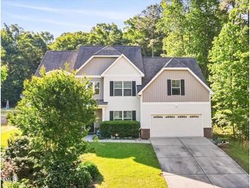 Charming two-story home with a well-manicured lawn, mature trees, and a two-car garage at 2207 Wimberly Woods Dr, Sanford, NC 27330