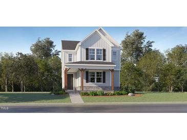 Charming two-story home with a covered porch and landscaped front yard offering great curb appeal at 409 Cresting Wave Dr, Wake Forest, NC 27587