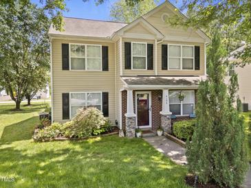 Charming two-story home features a well-manicured lawn and a welcoming front porch with brick and stone accents at 4104 Panther Creek Pkwy, Durham, NC 27704