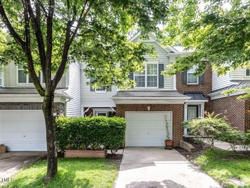 Charming two-story townhome with brick accents, a garage, and a well-manicured lawn with mature landscaping at 4206 Camden Woods Ct, Raleigh, NC 27612