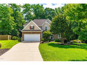 Charming two-story home with stone accents, mature landscaping, and a spacious driveway at 509 Fish Pond Ct, Rolesville, NC 27571