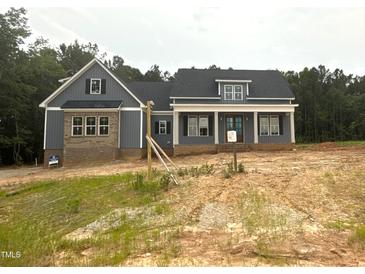 Charming craftsman-style home featuring gray siding, brick accents, and inviting front porch with columns at 60 Stream View Way, Spring Hope, NC 27882