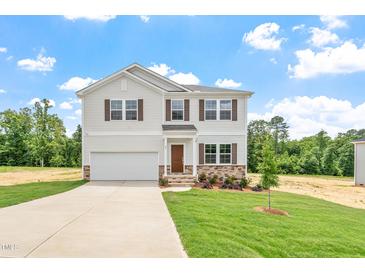 Charming two-story home featuring a well-manicured lawn and an attached two-car garage at 95 Cordoba Dr, Franklinton, NC 27525
