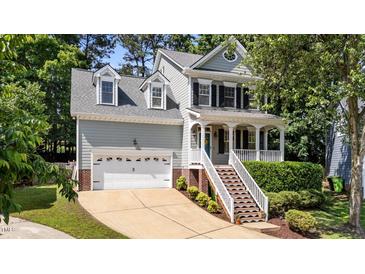 Charming two-story home featuring a welcoming front porch, dormer windows and an attached two car garage at 104 Kylesku Ct, Apex, NC 27502