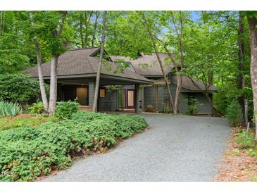 Charming gray home featuring a covered entrance and surrounded by lush greenery at 106 Mill Rock Ct, Carrboro, NC 27510