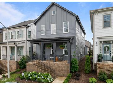Charming gray two-story home with a welcoming front porch and beautifully landscaped front yard at 117 Banning Dr, Pittsboro, NC 27312