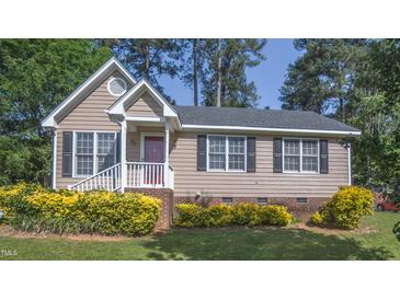 Charming single-Gathering home with neat front yard landscaping, dark shutters, and a cozy front porch at 133 Parkhaven Ln, Garner, NC 27529