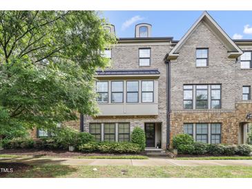 Attractive brick townhome featuring a covered porch and manicured landscaping at 1602 Bowery Dr, Raleigh, NC 27607