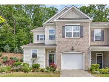 Charming townhome with a manicured lawn, attached garage, and a mix of brick and siding at 161 Walking Path Pl, Hillsborough, NC 27278