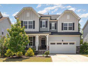 Charming two-story home with a manicured lawn, a two car garage and elegant gray and white color scheme at 2885 Farmhouse Dr, Apex, NC 27502
