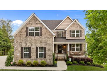 Charming brick home with manicured lawn, covered front porch, and detailed architectural features at 4420 Bonnie Loch Dr, Burlington, NC 27215