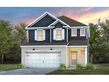 Charming two-story home featuring a brick facade, a two-car garage, and a cozy front entrance at 501 Providence Springs Ln, Fuquay Varina, NC 27526