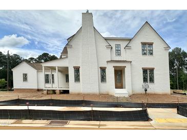 A charming, two-story home boasts a neutral exterior, inviting entrance, and attached side structure, perfect for modern living at 6501 Burnette Flower Way, Raleigh, NC 27612