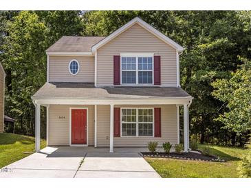 Charming two-story home with red door and shutters and landscaped front yard at 6604 Frogstool Ln, Raleigh, NC 27610