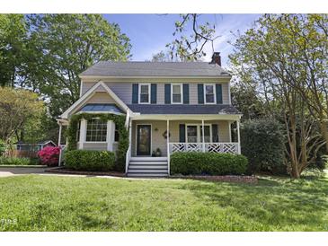 Charming two-story home featuring a well-manicured lawn, front porch, bay window, and beautiful landscaping at 8608 Cheerful Ct, Raleigh, NC 27615