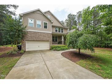 Charming two-story home with a well-maintained yard, a two-car garage, and a welcoming front porch at 1009 Blue Larkspur Ave, Wake Forest, NC 27587