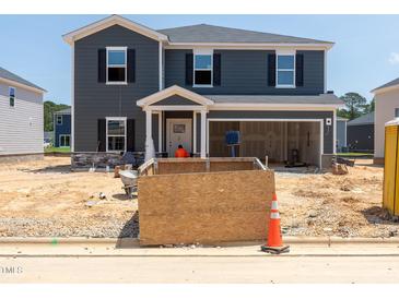 New construction two-story home featuring a welcoming front porch and a spacious two car garage at 1105 Landen Creek Ln, Zebulon, NC 27597