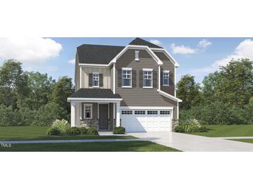 Charming two-story home featuring a stylish facade, a two-car garage, and manicured landscaping at 1228 Coral Cay Bnd, Wake Forest, NC 27587