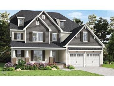 Charming two-story home featuring a two-car garage, dormer windows, and well-manicured landscaping at 1412 Auman Rd, Raleigh, NC 27603