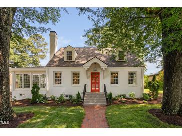 Charming two-story home featuring a red front door, brick walkway, and well-manicured lawn at 3210 Merriman Ave, Raleigh, NC 27607