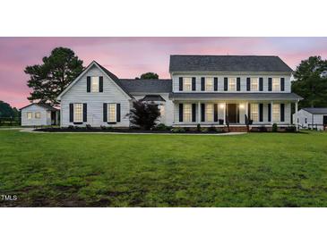 Charming white two-story home featuring black shutters, a covered porch and a lush green lawn at 4600 Smithfield Rd, Wendell, NC 27591
