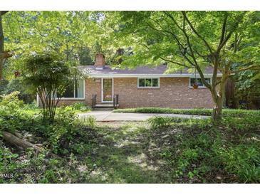 Charming brick home with a well-manicured front yard and mature trees at 712 Beaver Dam Rd, Raleigh, NC 27607