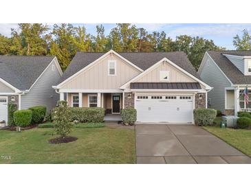 Charming home featuring a two-car garage, well-manicured lawn, and classic architectural details at 80 Bramble Ln, Clayton, NC 27527
