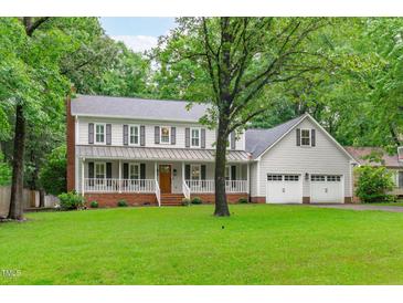 Charming two-story home with a welcoming front porch, attached garage, and lush green lawn at 8505 Stonegate Dr, Raleigh, NC 27615
