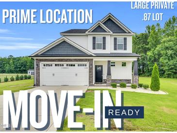 Charming two-story home with a two car garage, landscaping, and a large, private lot is move-in ready at 97 Arapahoe Dr, Kenly, NC 27542