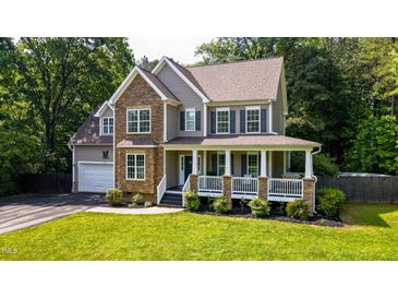 Charming two-story home with stone accents, a welcoming front porch, and lush green lawn at 973 Rebecca Ln, Siler City, NC 27344